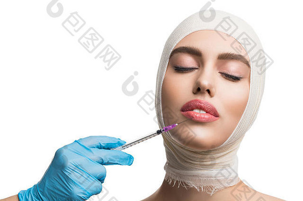 一名妇女用绷带包扎了她的头，正在接受嘴唇注射