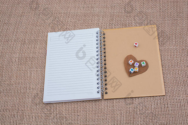画布上的笔记本上有心形的彩色立方体