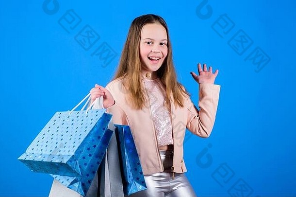 童装。店员拿着包裹。销售和折扣。拿着购物袋的小女孩。快乐的孩子。小女孩网上购物。节省购买费用。孩子们的时尚。儿童商店。时尚风格。