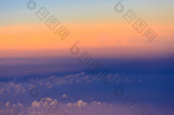 美丽的夕阳天空，云层上方有着引人注目的光线。飞机机舱视图