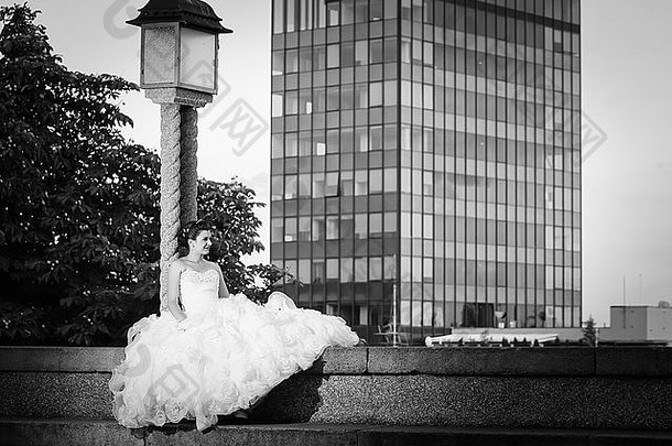 新娘坐着混凝土墙倾斜街灯摩天大楼萨格勒布背景