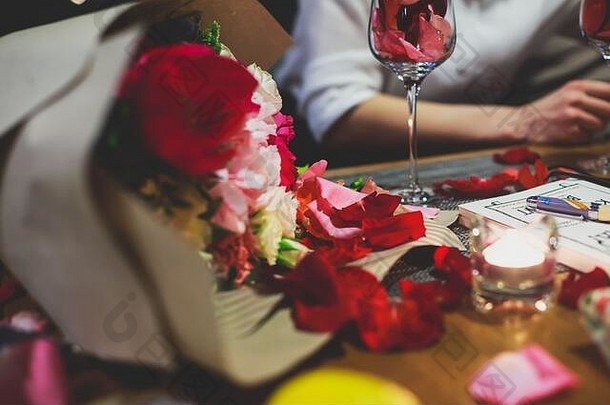 美丽的玻璃玫瑰树叶玫瑰花瓣玫瑰花瓣浪漫的日期酒蜡烛烛光庆祝夫妇引入