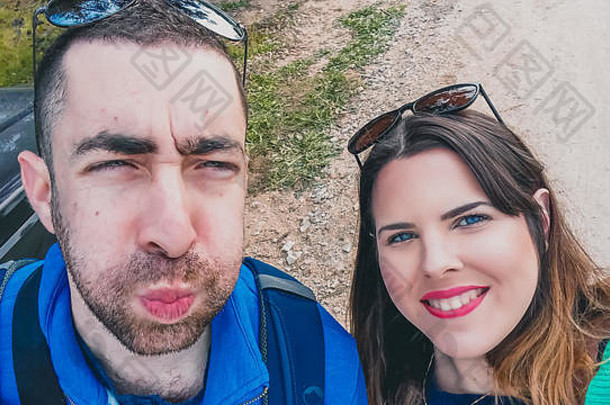 快乐年轻的夫妇愚蠢的有趣的脸采取自拍图片智能手机相机公园