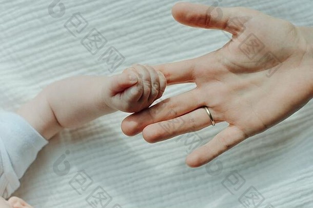 新生儿的手牵着母亲的手。妈妈和她的孩子。幸福家庭的概念。