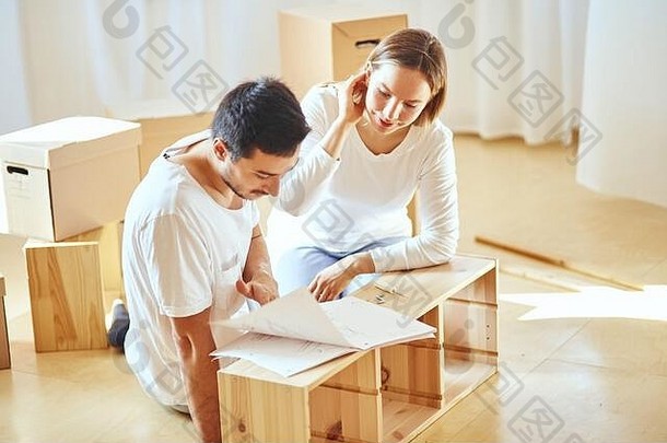 年轻的夫妇安装家具房子指令
