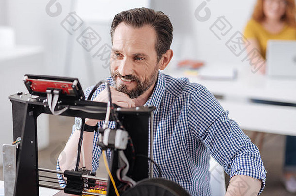 快乐的设计师坐在3d打印机前