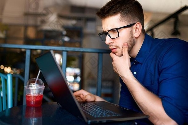 体贴的年轻迷人的时髦自由职业者，在阁楼咖啡馆远程使用笔记本电脑。在咖啡店浏览互联网的商人。博客写给