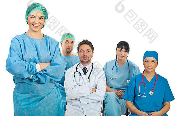 外科医生、女教师站在摄像机前，双臂交叉，四名医科学生坐在椅子上