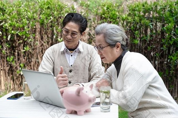 一对亚洲老年夫妇正在使用笔记本电脑