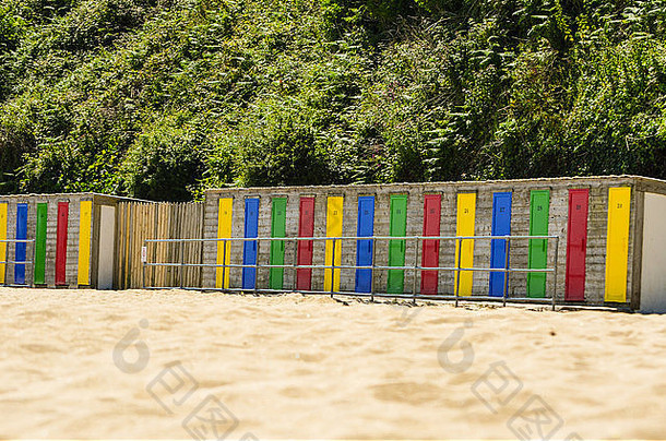 沙滩边上一排五颜六色的海滩小屋。