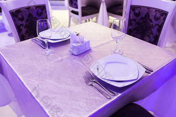 一家新开的豪华餐厅内摆放着空杯子和盘子，桌上有盖