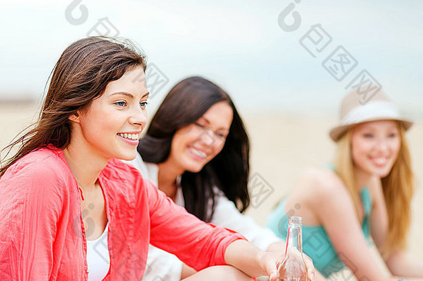 海滩上喝饮料的女孩