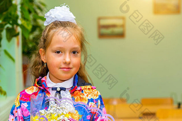 一年级的小女孩，在知识日第一天上学。九月穿着制服、打着蝴蝶结的小学生在教室里摆姿势。预计起飞时间