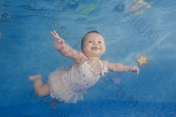 婴儿女孩学习游泳水下婴儿游泳水下池蓝色的水背景
