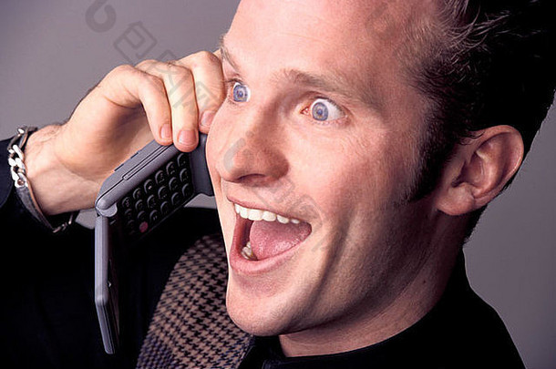 一个快乐兴奋的男人在电话里谈论着让他吃惊的令人兴奋的消息