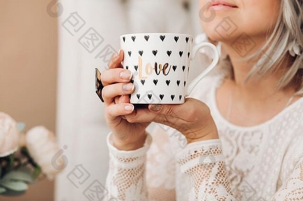 拿着一杯漂亮咖啡的女人。