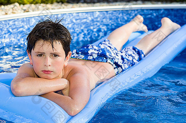 快乐年轻的男孩充气水懒人游泳池