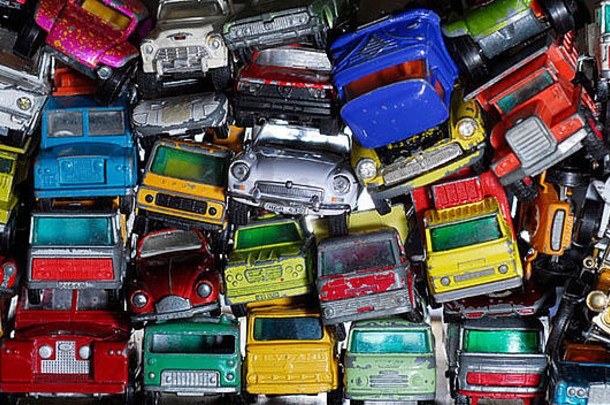 在一个儿童玩具废料场里，一堆五颜六色的金属玩具车。玩具在一个家庭中代代相传。
