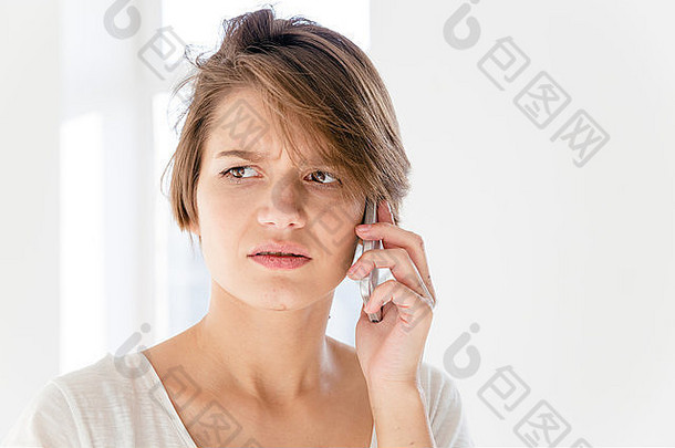 担心打扰年轻的女人会说话的移动电话白色背景