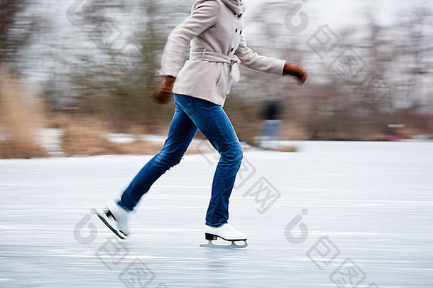 年轻的女人冰滑冰在户外池塘冻结冬天一天