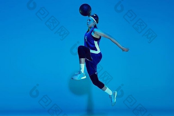 领袖年轻的高加索人女篮球球员培训prcticing球孤立的蓝色的背景霓虹灯光概念体育运动运动能源动态健康的生活方式
