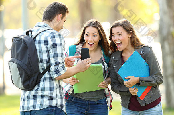 学生在公园的户外向朋友展示手机内容