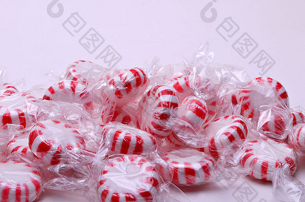 一把红白相间的条纹薄荷糖放在白色背景上。