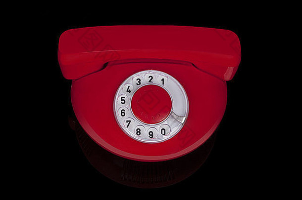 60年代的红色圆形复古手机，背景为黑色。怀旧物品。