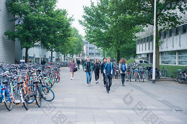 荷兰蒂尔堡大学校园周围的图片，显示人们在大学校园里散步和骑<strong>自行车</strong>