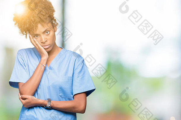 一位年轻的非裔美国女医生，在与世隔绝的背景下思考，双臂交叉，看起来很疲惫，对抑郁症感到厌倦。