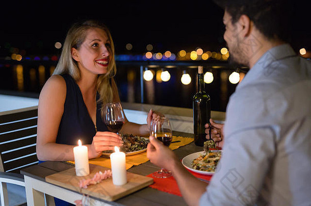 美丽的年轻夫妇在屋顶上享用浪漫晚餐