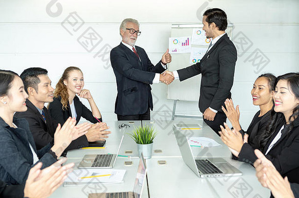高级上司或CEO提拔年轻下属。两位商人握手，祝贺晋升。庆祝推广活动。