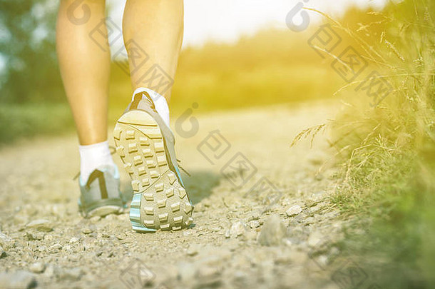 穿着运动鞋或登山鞋走路的女人。慢跑、徒步旅行或夏季户外训练，激发灵感，激发健康和健身理念。