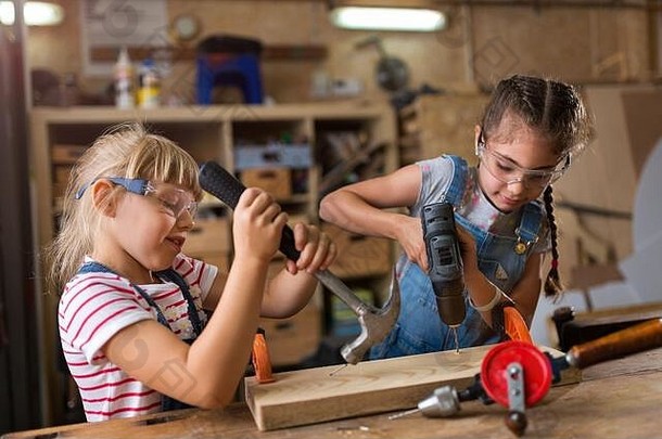 两个年轻女孩在<strong>车间</strong>做木工活