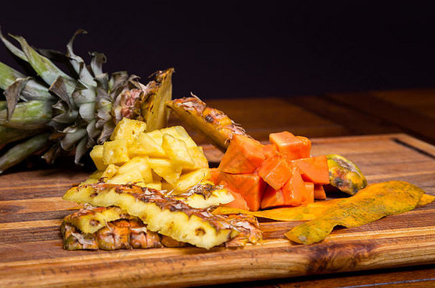 新鲜切好的菠萝和木瓜放在木板上。