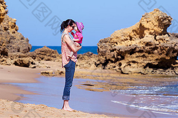 一位母亲和她的女儿在海滩上快乐地玩耍