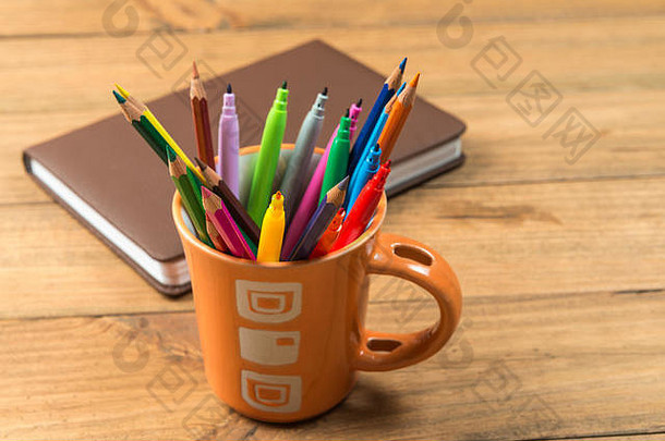 回到学校的概念。装满马克笔和彩色铅笔的杯子。