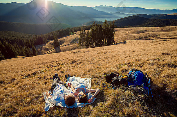 一对<strong>浪漫</strong>的新婚夫妇躺在山上的草地上。