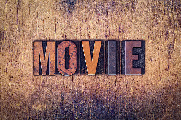 “电影”这个词是在一个陈旧的木制背景上用肮脏的老式活版印刷字体写的。