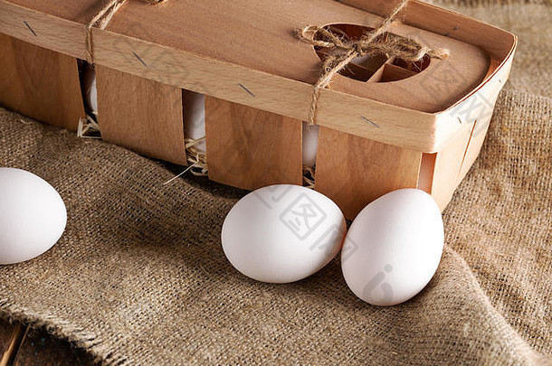 特写镜头白色鸡蛋环保木包装盒子粗麻布包装使条薄木单板