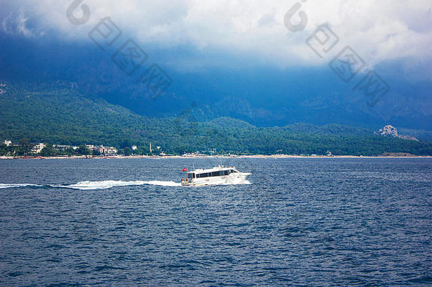 蓝色平静的地中海、群山和白色游艇