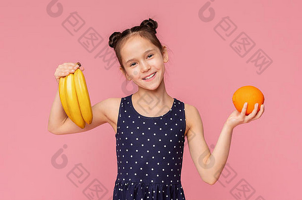 可爱的快乐的女孩持有新鲜的香蕉橙色水果