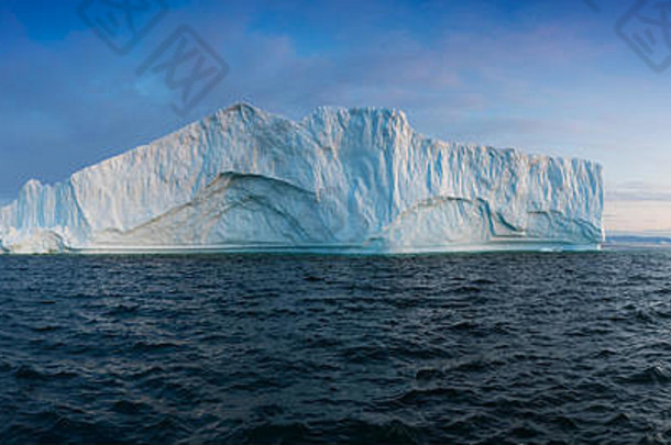 日落时的冰山。格陵兰的自然和景观。迪斯科湾。西格陵兰。夏日午夜的阳光和冰山。冰峡湾的蓝色大冰块。