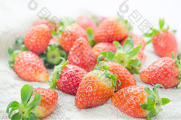 将新鲜的红色<strong>草莓</strong>盖在麻布和成熟<strong>水果</strong>上