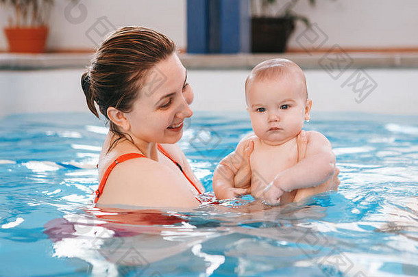 白色高加索人妈妈。转换新生儿婴儿浮动游泳池婴儿潜水水健康的活跃的生活方式家庭活动早期