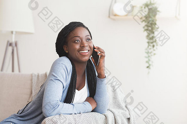 年轻的黑人妇女在家和朋友打手机