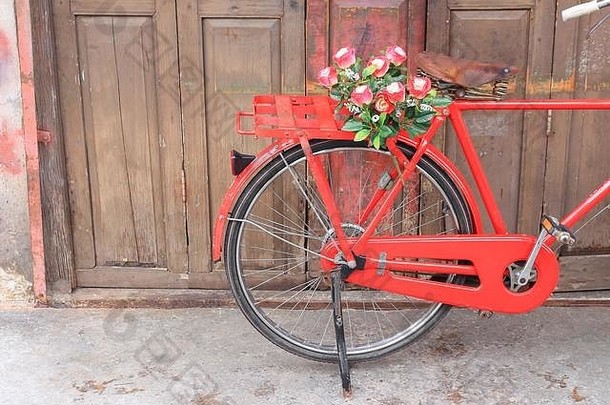 马鞍上的花朵红色自行车经典复古墙木背景