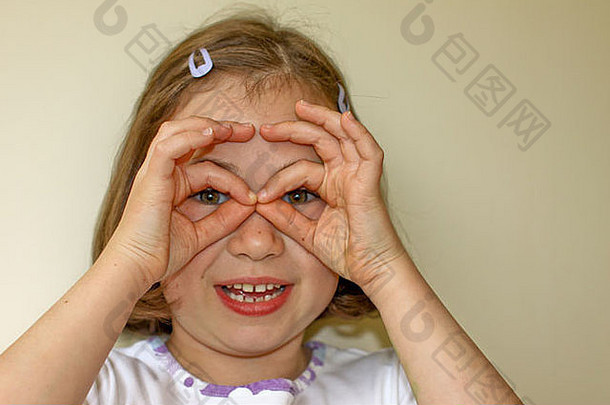 年轻的女孩屏蔽眼睛手指