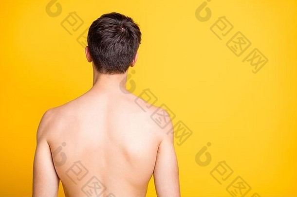 照片的背面是一个男人从你身边转过身来，展示他纯净的皮肤和健康的脊梁骨，被隔离在黄色鲜艳的颜色上