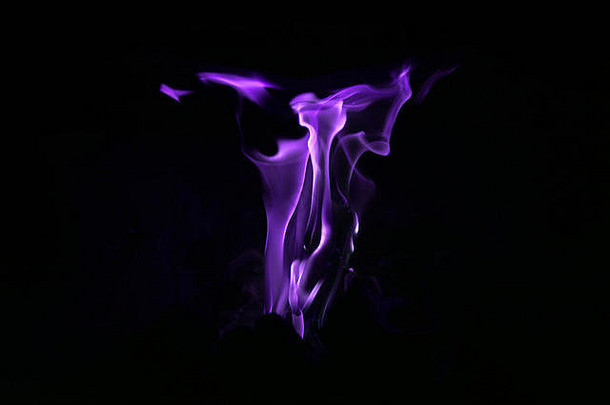 紫色抽象的火焰，黑暗背景下烟囱里的火，的概念。